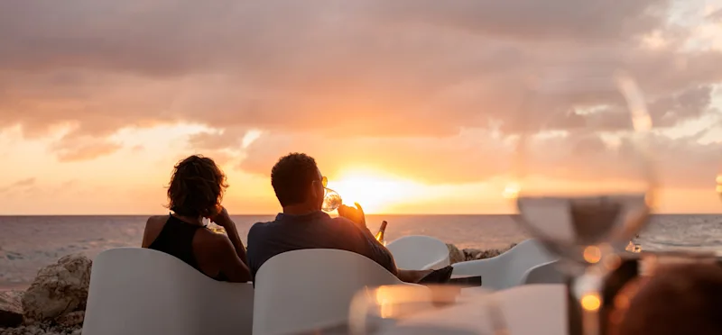 Couple enjoying sunset with wine at the beach