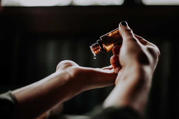 Person pouring oil in open hand
