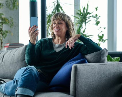 An Aspen Dental veneers patient smiles on a video call. 