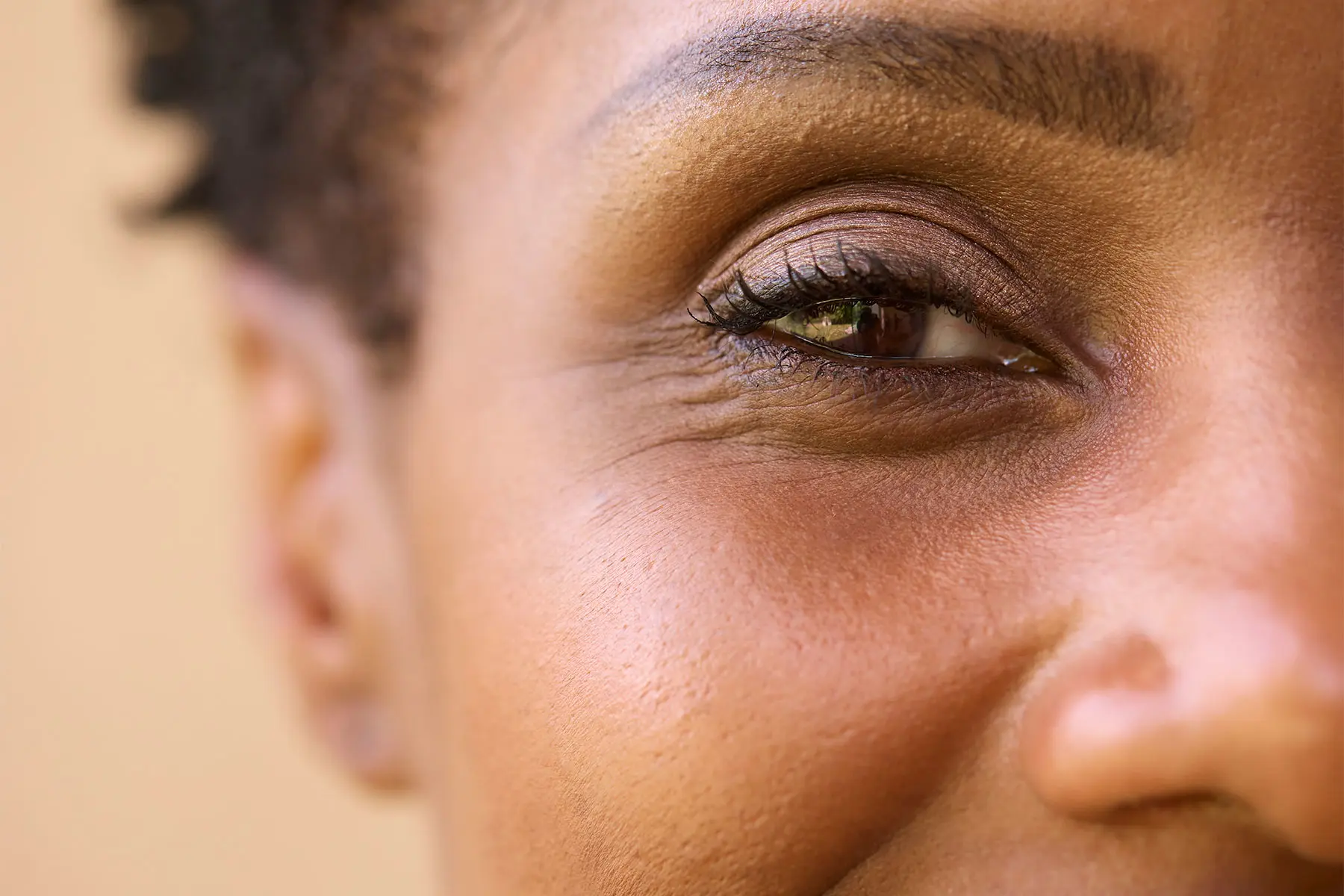 Close-up photo of a black woman with mature skin, smiling. header