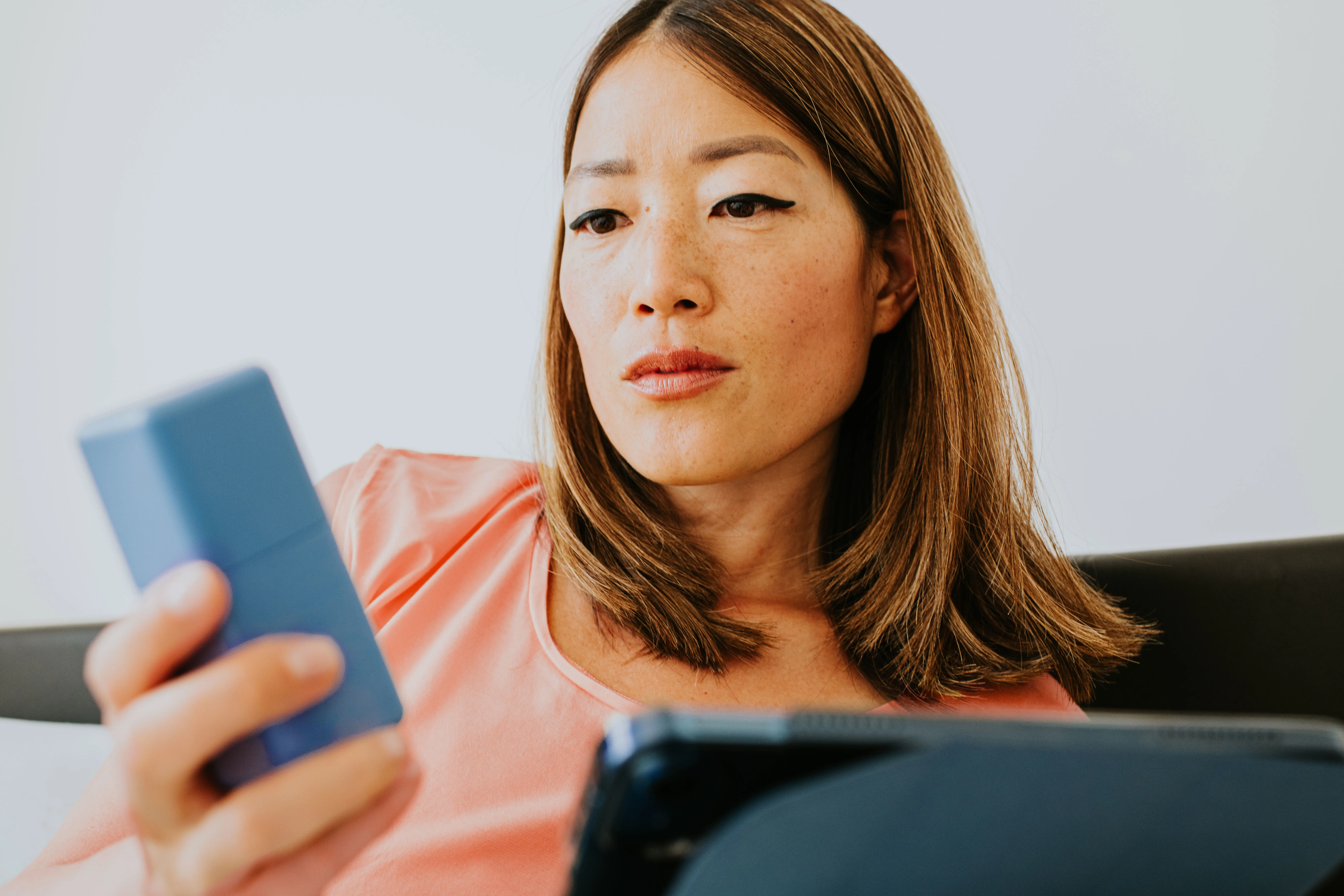 Woman in her early 40s examining ingredient list on a bottle of cream to treat dark spots. header