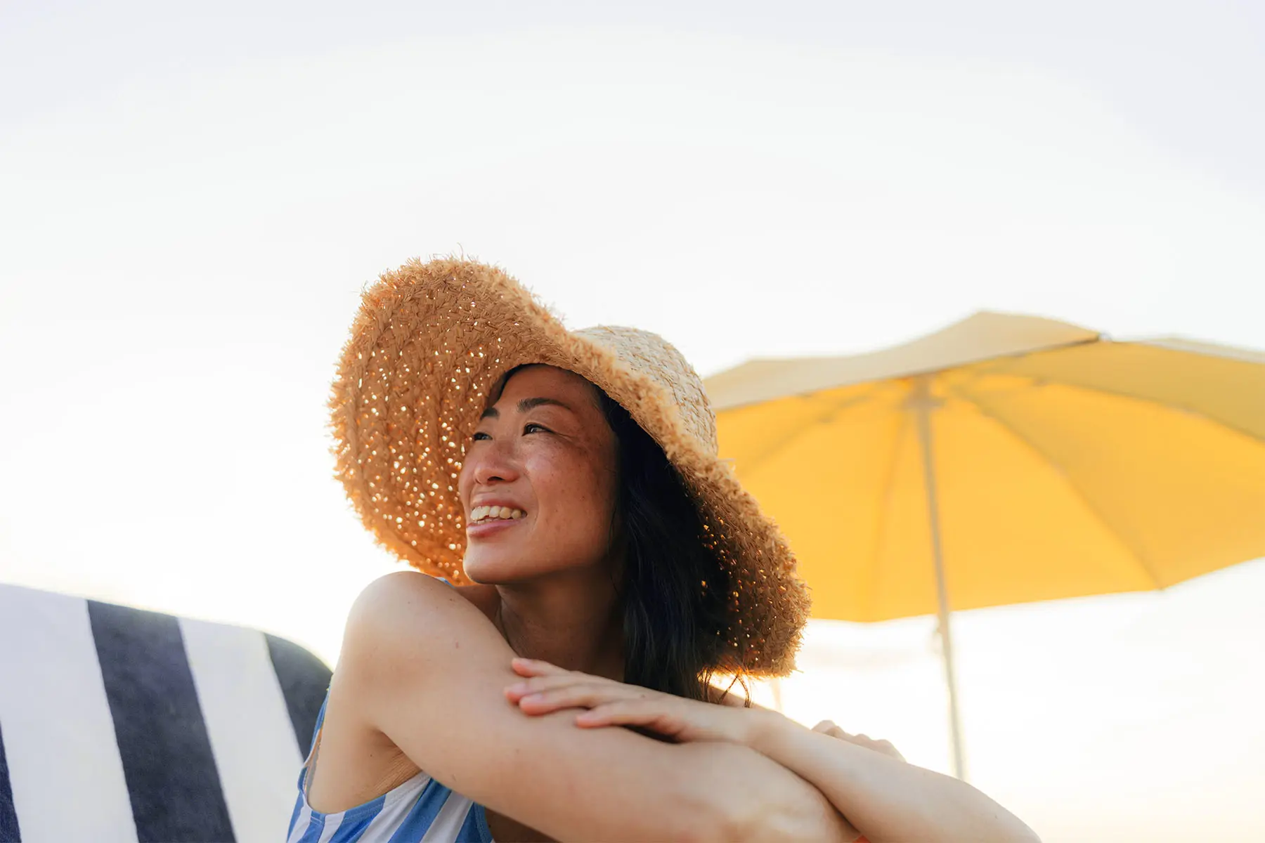 Asian woman in a swimsuit and straw hat for sun protection. header
