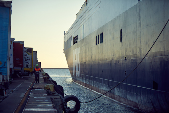 An employee walks along a DFDS ship docked at Trieste