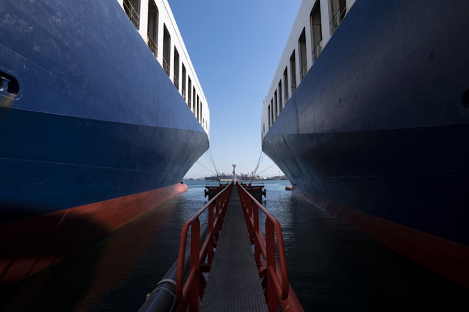 view from the middle of two DFDS Freight shipping vessels, docked side by side