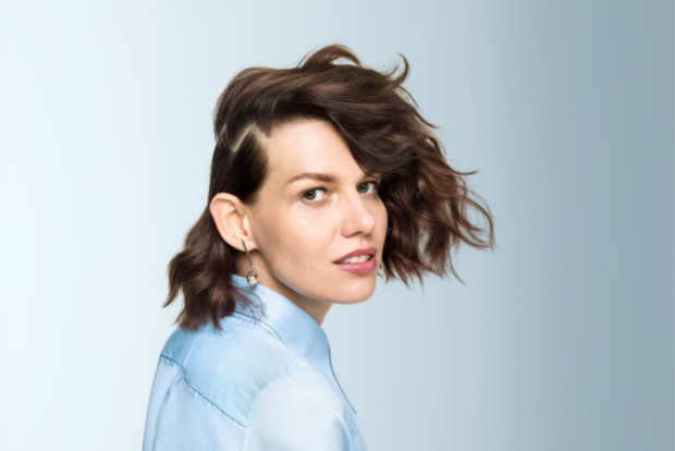 woman with dark wavy hair in an unusual hairstyle