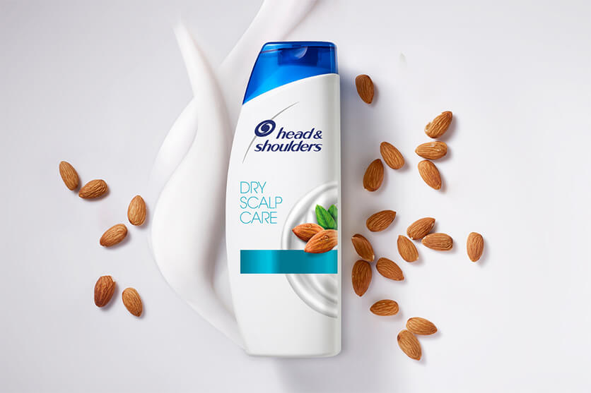 Bottle of Dry Scalp Care Shampoo surrounded by almonds