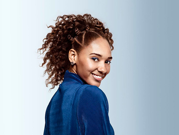 A smiling woman with beautiful, brown and curly hair