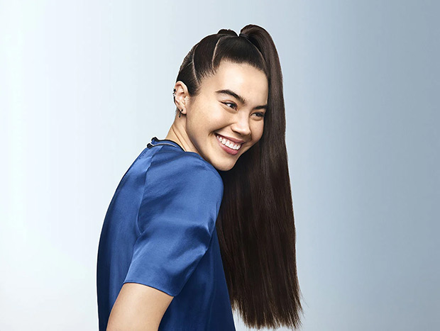 Woman with long, straight, black hair pinned up in a ponytail.