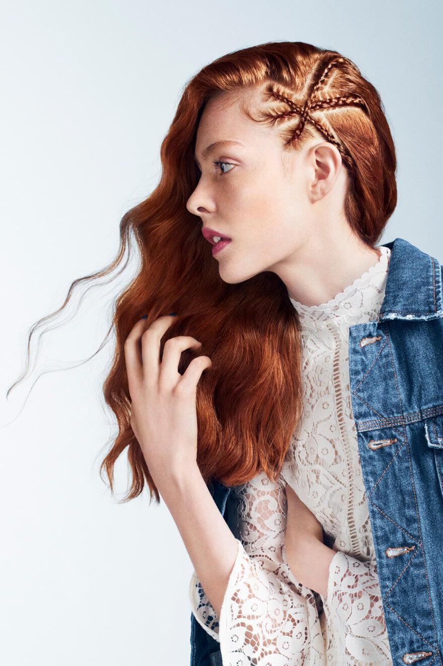 Woman looking straight on the site touching her hair.