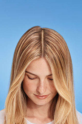A woman with long blonde hair is looking down.