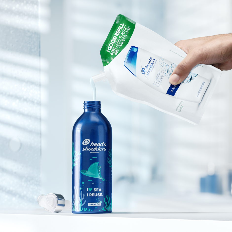 Head&Shoulders aluminium bottle filled in with shampoo from refill pack on the bathroom background.