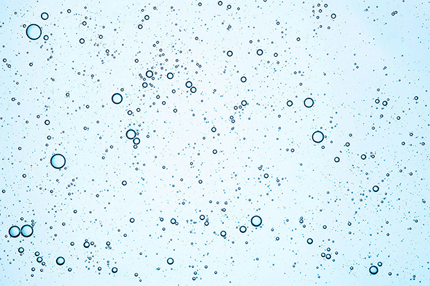 Bubbles of the air in the water on the light blue background.