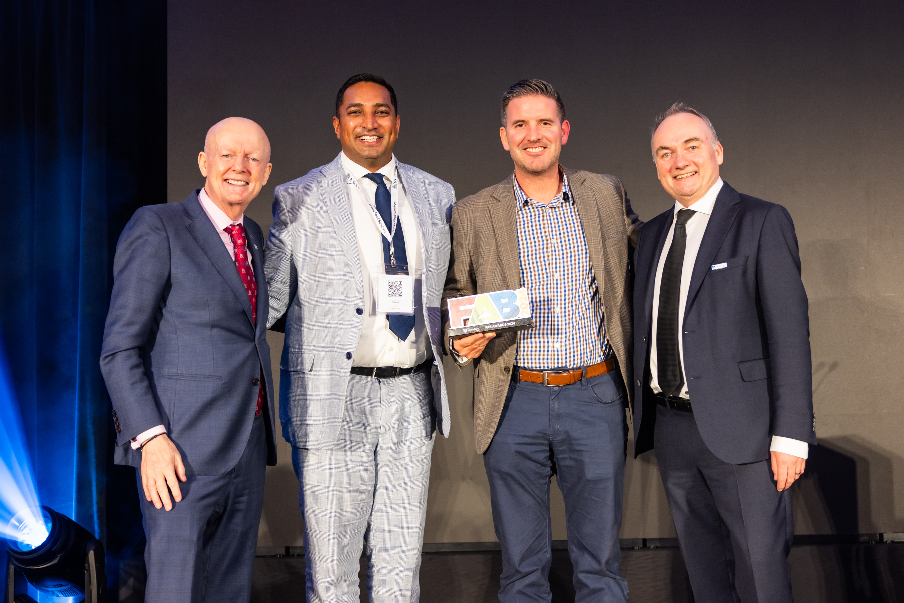 Awards ceremony, four men posing with award