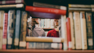 people talking in a library with books