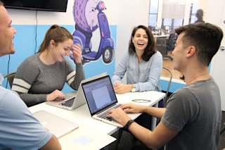 people laughing around a conference table
