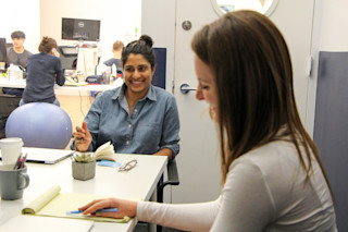 Two girls smiling happy working at a desk