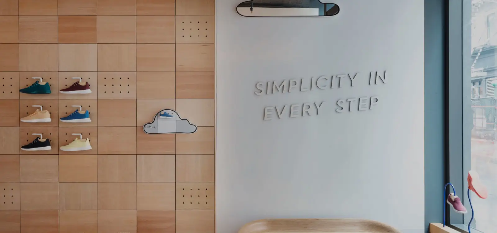 wall in allbirds shop that says 'simplicity in every step', shoe display