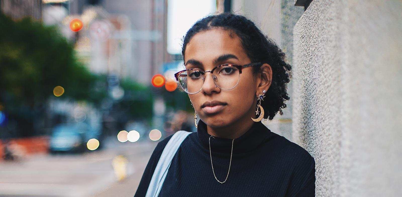 black woman leaning against wall