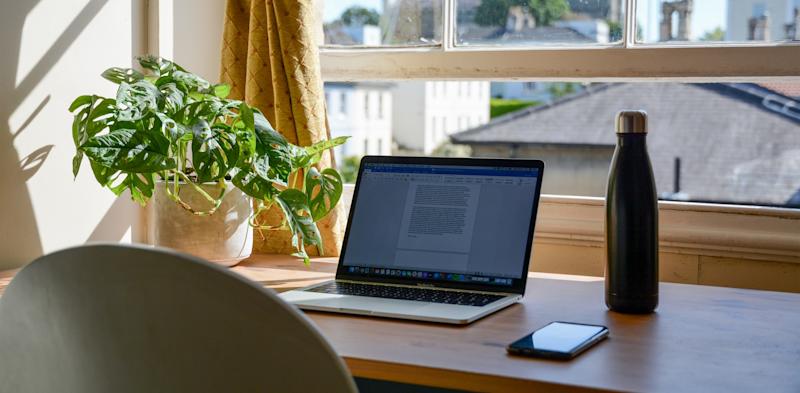 remote work desk with mobile phone, laptop and water bottle