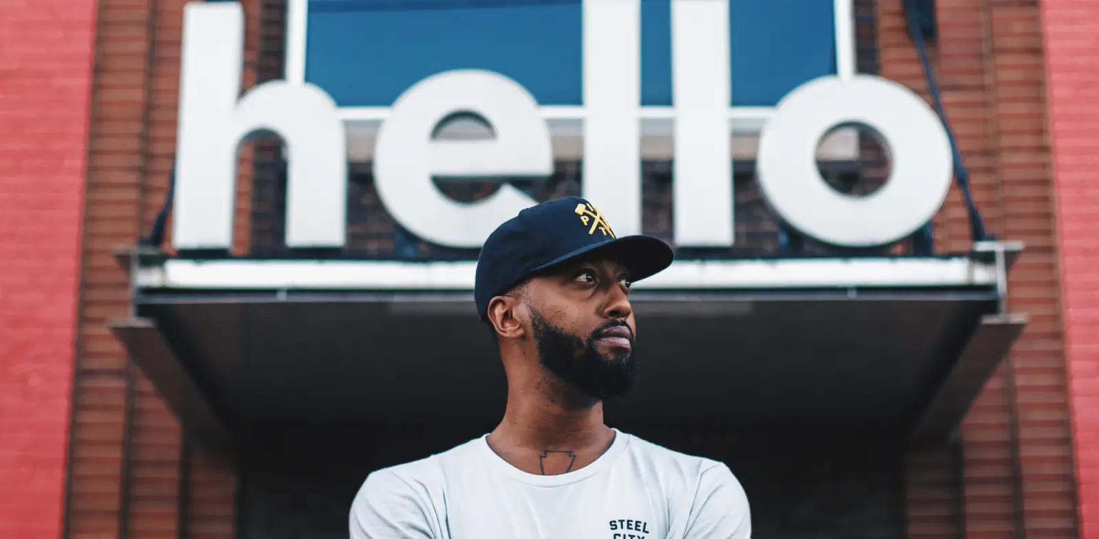 black man standing in front of hello sign