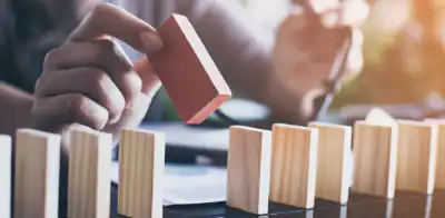 person with colored domino stack, cascading okrs like dominos