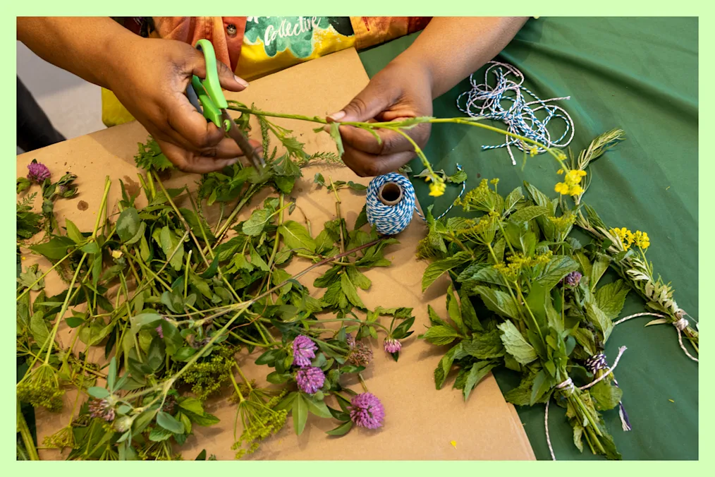 An adult and 2 children planting seeds in a garden