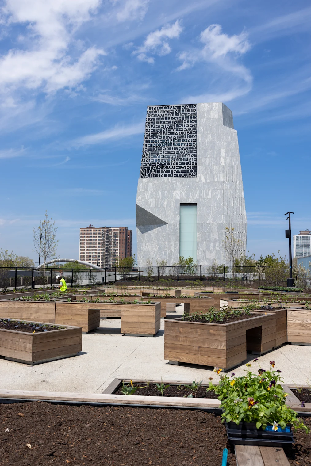 Raised garden beds planted with leafy greens in front of the Obama Presidential Center Museum
