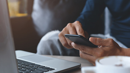 Close up of man booking an Airbnb on his phone.