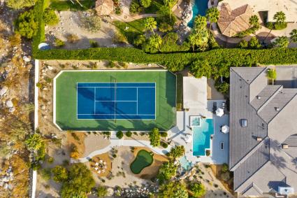 Aerial view of a large home with pool and tennis court