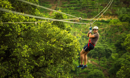 A person flys throught the sky on a zip line, one of the best things to do in Vail in summer. 