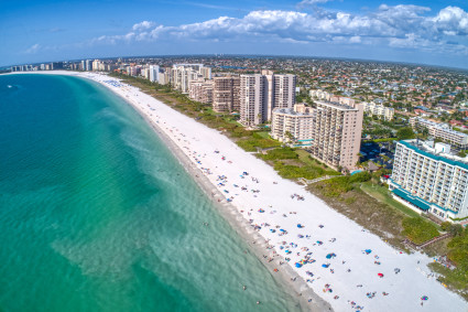 Aerial view of a large beach with condos and many people