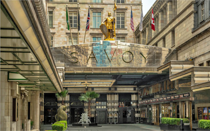 The Savoy, one of the iconic boutique hotels in London, features a golden statue and international flags above its entrance.