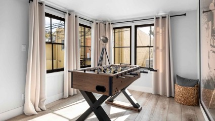 Bright room with a foosball table and open windows