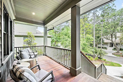Outdoor seating area of a Kiawah Island Pacaso vacation home featuring a wooden porch with chairs