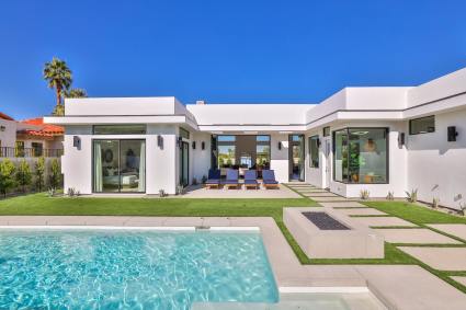 White, modern single story home with a pool and patio