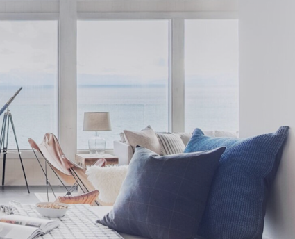 blue pillows on couch with ocean view