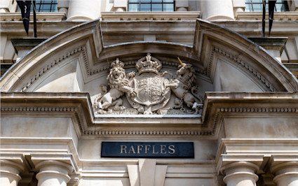 A photo shows the architectural detail above the entrance of Raffles London, one of the best luxury hotels in London.