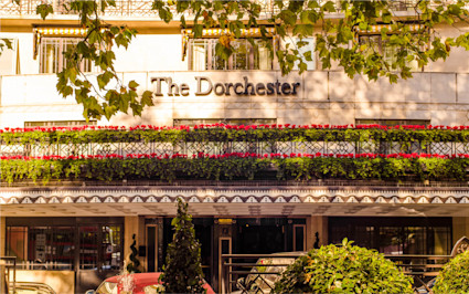 Renowned as one of the top hotels in London, The Dorchester showcases its exterior with lush floral arrangements on its balconies.