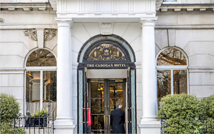 The Cadogan, a Belmond Hotel, stands elegantly. This luxury hotel in London features a grand entrance with a doorman.