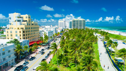 Cars line the street and people walk in the sand of Miami Beach, Florida, one of the top workcation destinations.