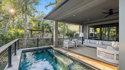 Oyster Rake outdoor plunge pool with covered lounge area with patio furniture arranged in a circle.