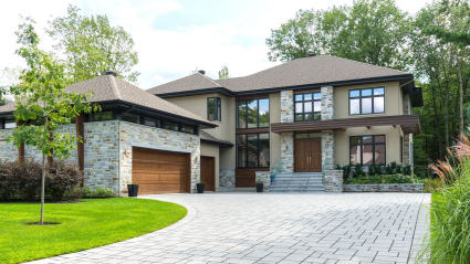 A luxury home with a brick driveway.