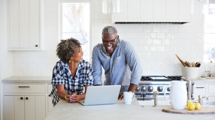 couple in kitchen looking at laptop