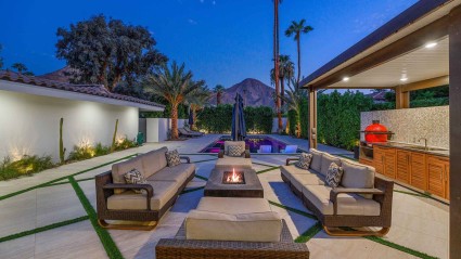 A cozy patio of an Indian Wells vacation home with stylish furniture and a fire pit, perfect for outdoor gatherings and relaxation.