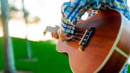 A person stums their guitar at a free concert, one of the top Steamboat Springs summer activities.