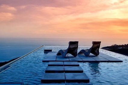 infinity pool overlooking ocean at sunset