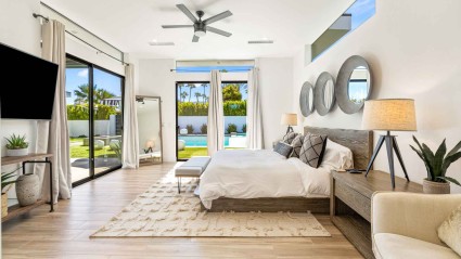 Bedroom of a Palm Springs second home with modern decor, a comfortable bed and views of the pool
