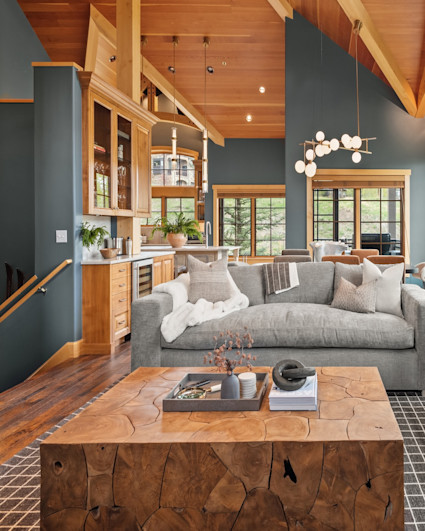 Mobile sized photo of Alpine Ridge living room with dark green colored walls with furniture arranged around a solid piece of wood for a coffee table.