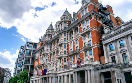 A low-angle shot captures the red-brick facade of the Mandarin Oriental Hyde Park, an acclaimed top London hotel