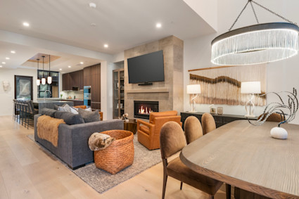 Snow King living area with furniture arranged in front of a fireplace with a wall-mounted flat screen tv hanging above.